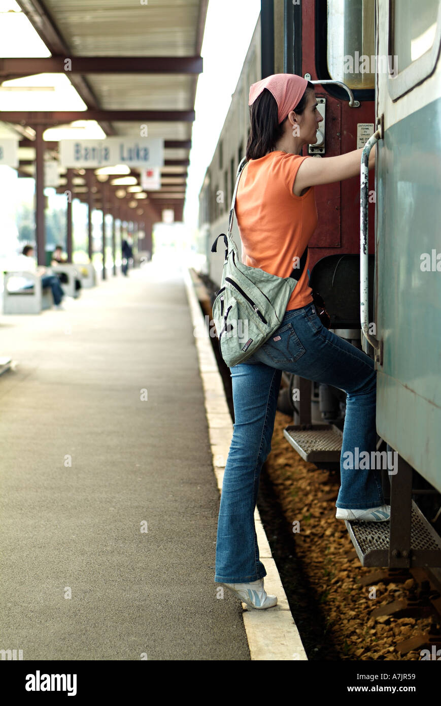 Femme s'embarquent dans un train à une gare ferroviaire Banque D'Images