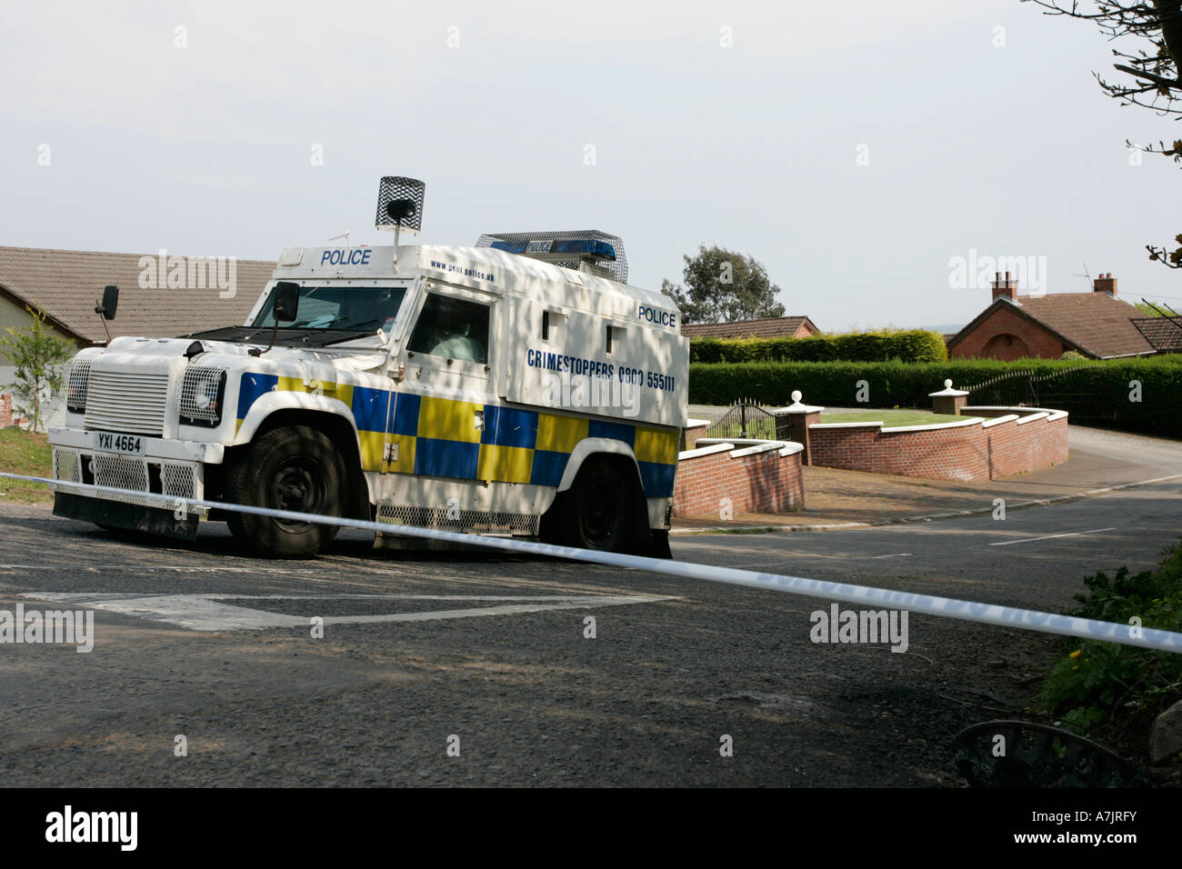 Land Rover police PSNI derrière la ligne bande à incident devant les maisons à l'extérieur de l'Irlande du Nord Belfast Banque D'Images