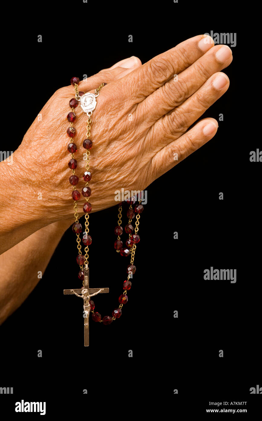 Une vieille femme asiatique détient ses mains en prière avec un rosaire Banque D'Images