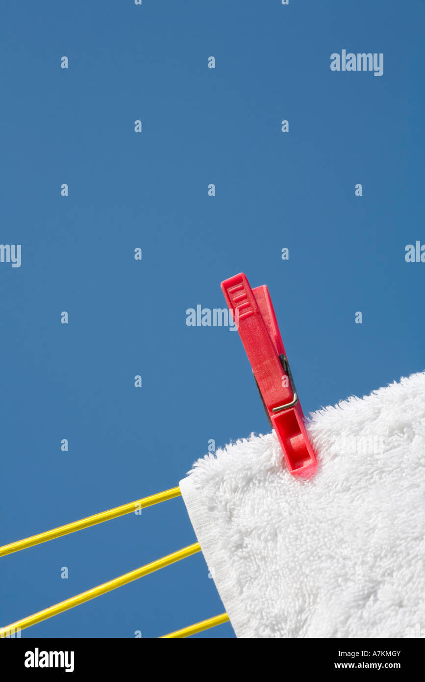 Une épingle à linge sur une serviette blanche et lave-line against a blue sky Banque D'Images