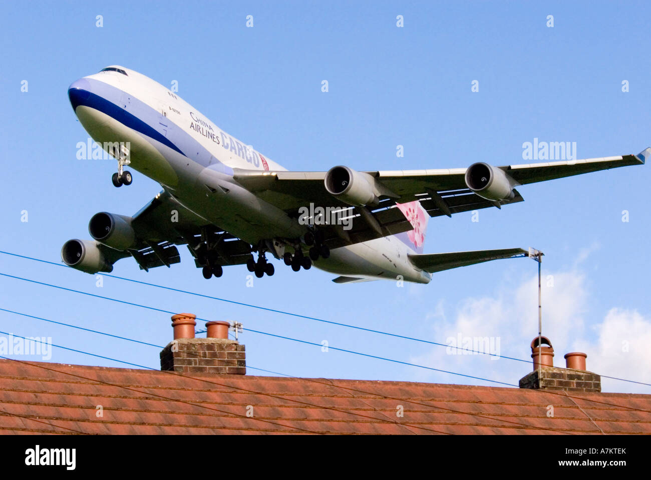 Un China Airlines Cargo Jumbo jet landing sur les toits de maisons. Banque D'Images