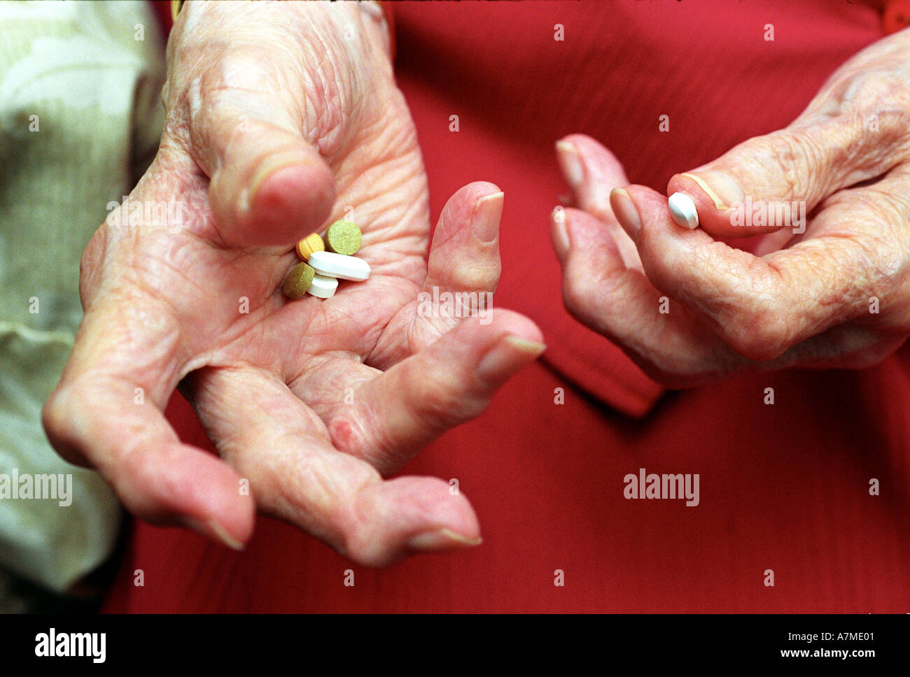 Close up d'un dames âgées mains arthritiques médicament holding tablets Banque D'Images