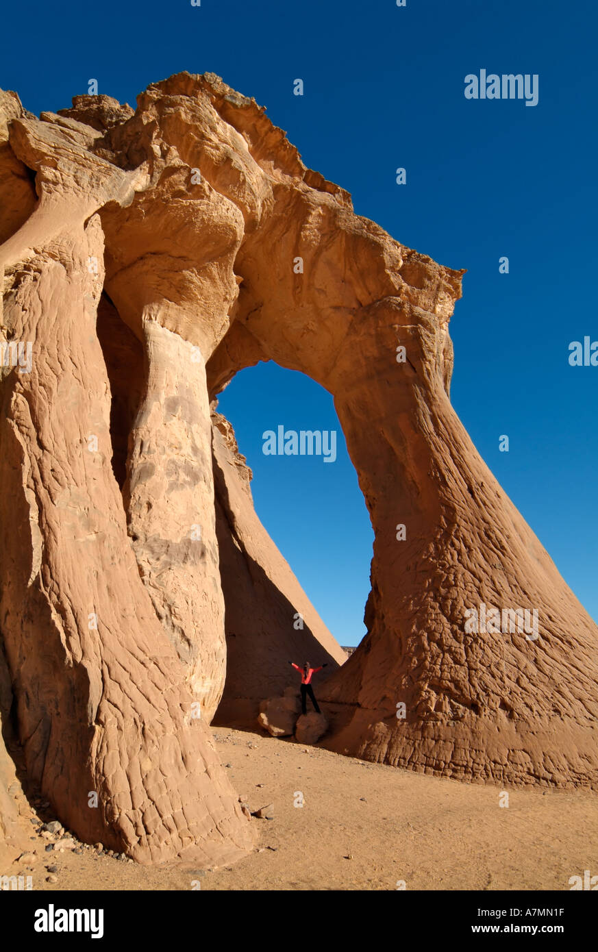 Les touristes explorant une arche naturelle, Jebel Acacus, désert du Sahara, la Libye Banque D'Images