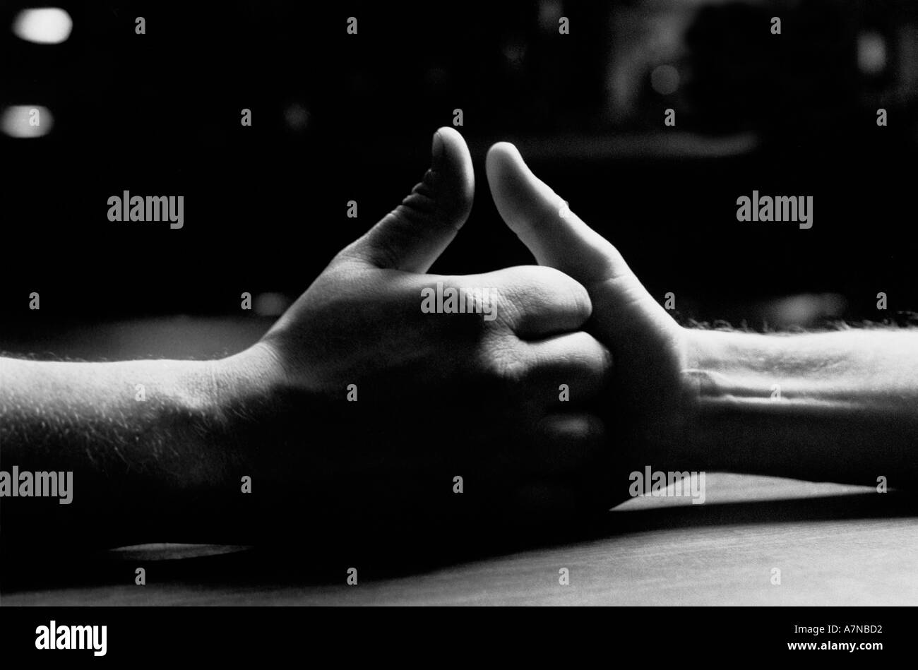 Saisir à deux mains les uns les autres sur une table dans la préparation d'un pouce wrestling contest Banque D'Images