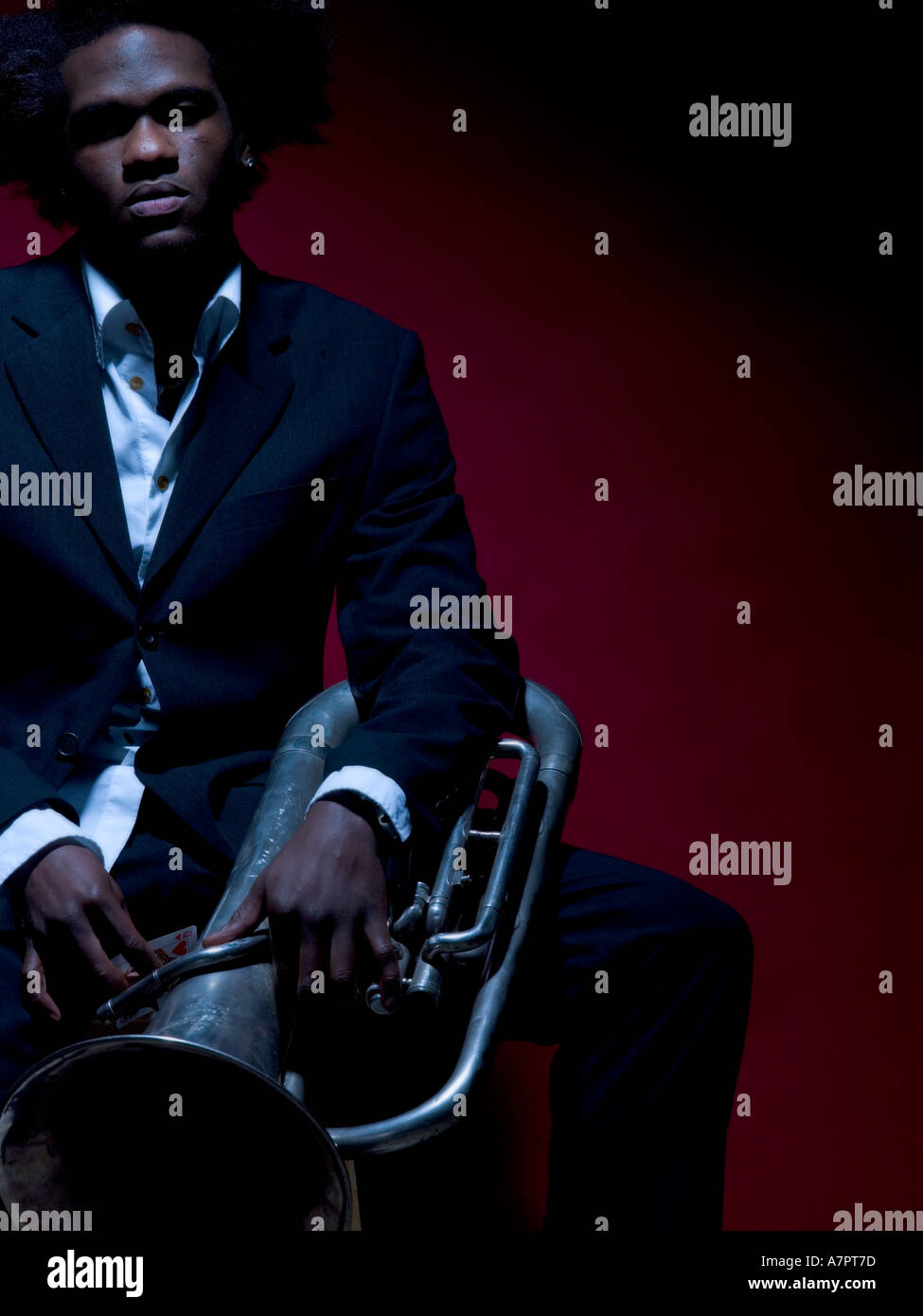 20 s de l'homme Afro Antillais assis hoding une corne français au tour Banque D'Images