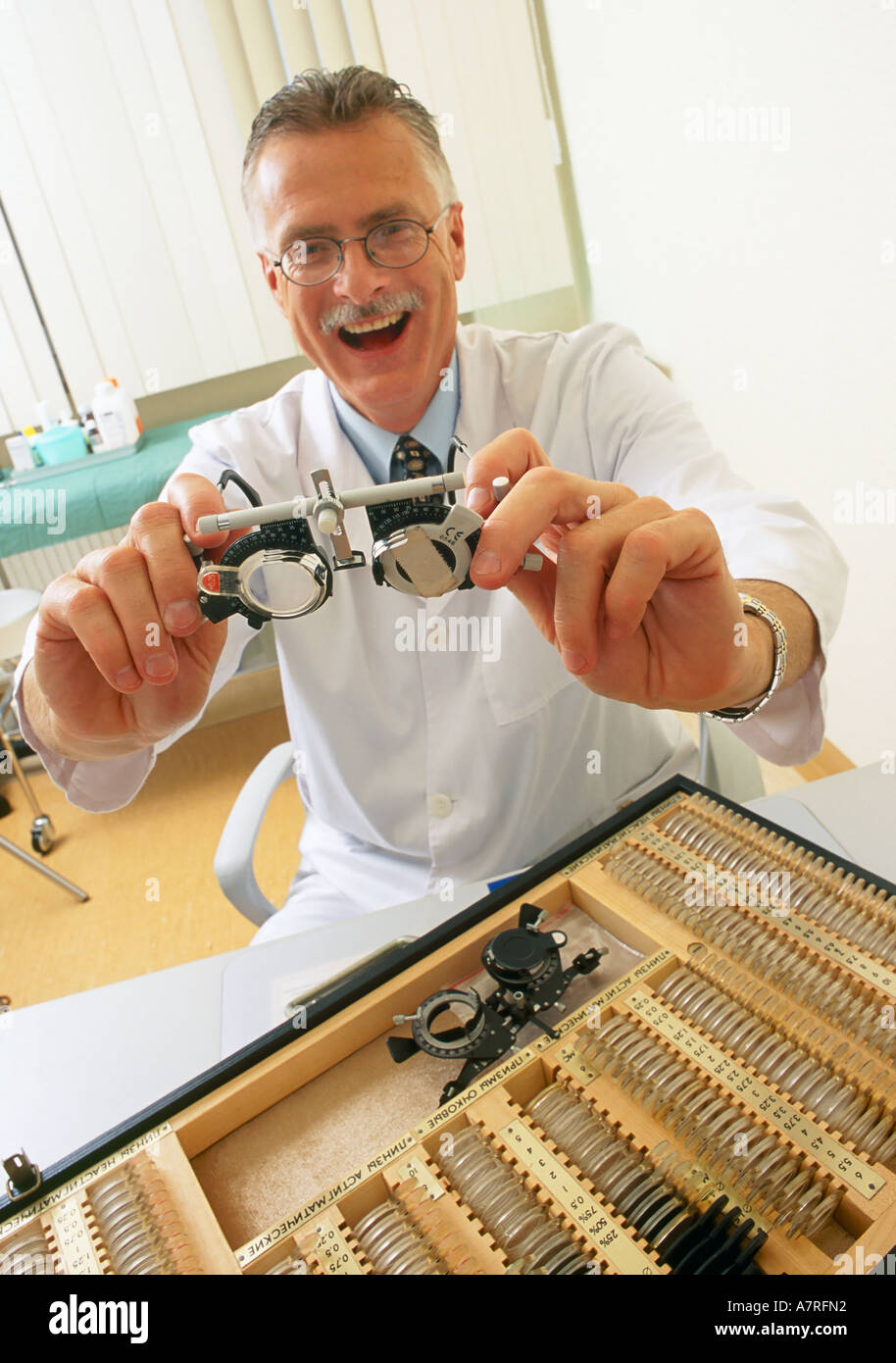 À l'intérieur du cabinet ambulatoire mature homme aux cheveux gris 4550 lunettes moustache sourire rire médecin ophtalmologiste optomeris Banque D'Images