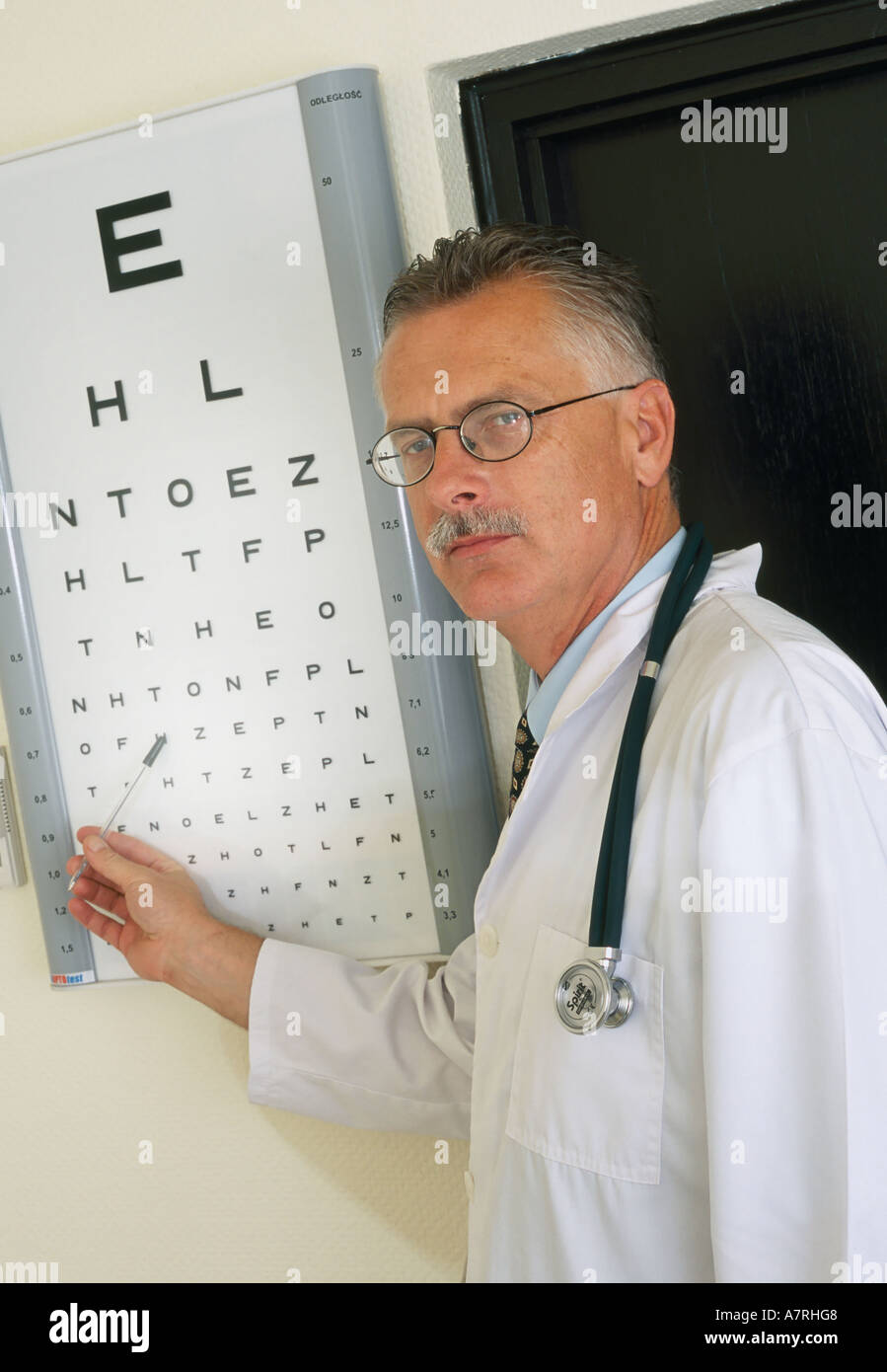 À l'intérieur du cabinet ambulatoire mature homme aux cheveux gris 4550 robe de médecin ophtalmologiste lunettes moustache optomerist b stéthoscope Banque D'Images