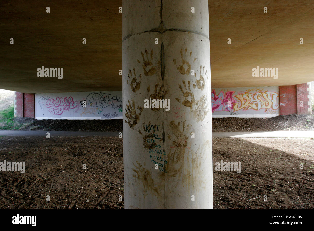 Le métro sous la route de graffiti et main boueuse imprime sur colonnes de soutien Banque D'Images