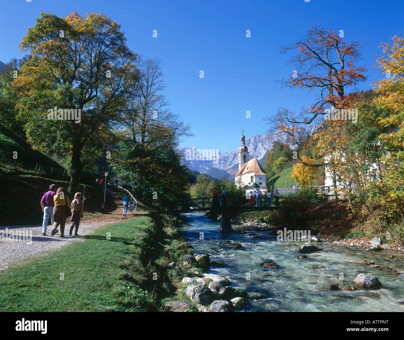 Quelques touristes sur riverside en arrière-plan l'Église Saint-sébastien Ramsau bei Berchtesgaden Berchtesgadener Land Bavière Allemagne Banque D'Images