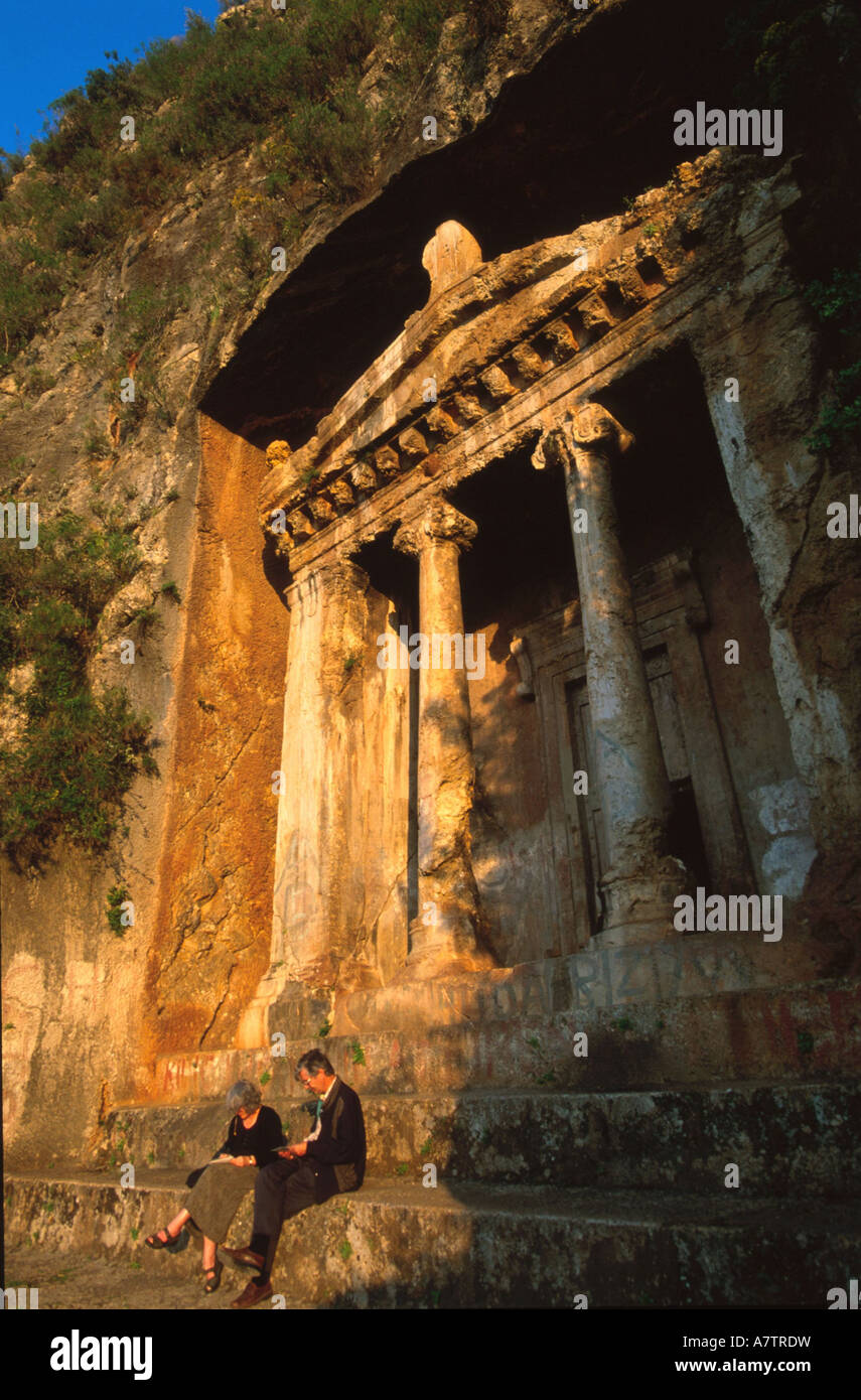 Deux personnes assises sur les marches du tombeau antique Turquie Banque D'Images