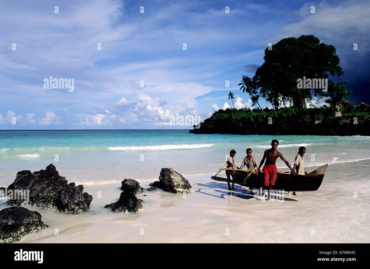 République des Comores, l'île de Grande Comore, Chomoni village, les pêcheurs transportant une pirogue sur la plage de Galawa Banque D'Images