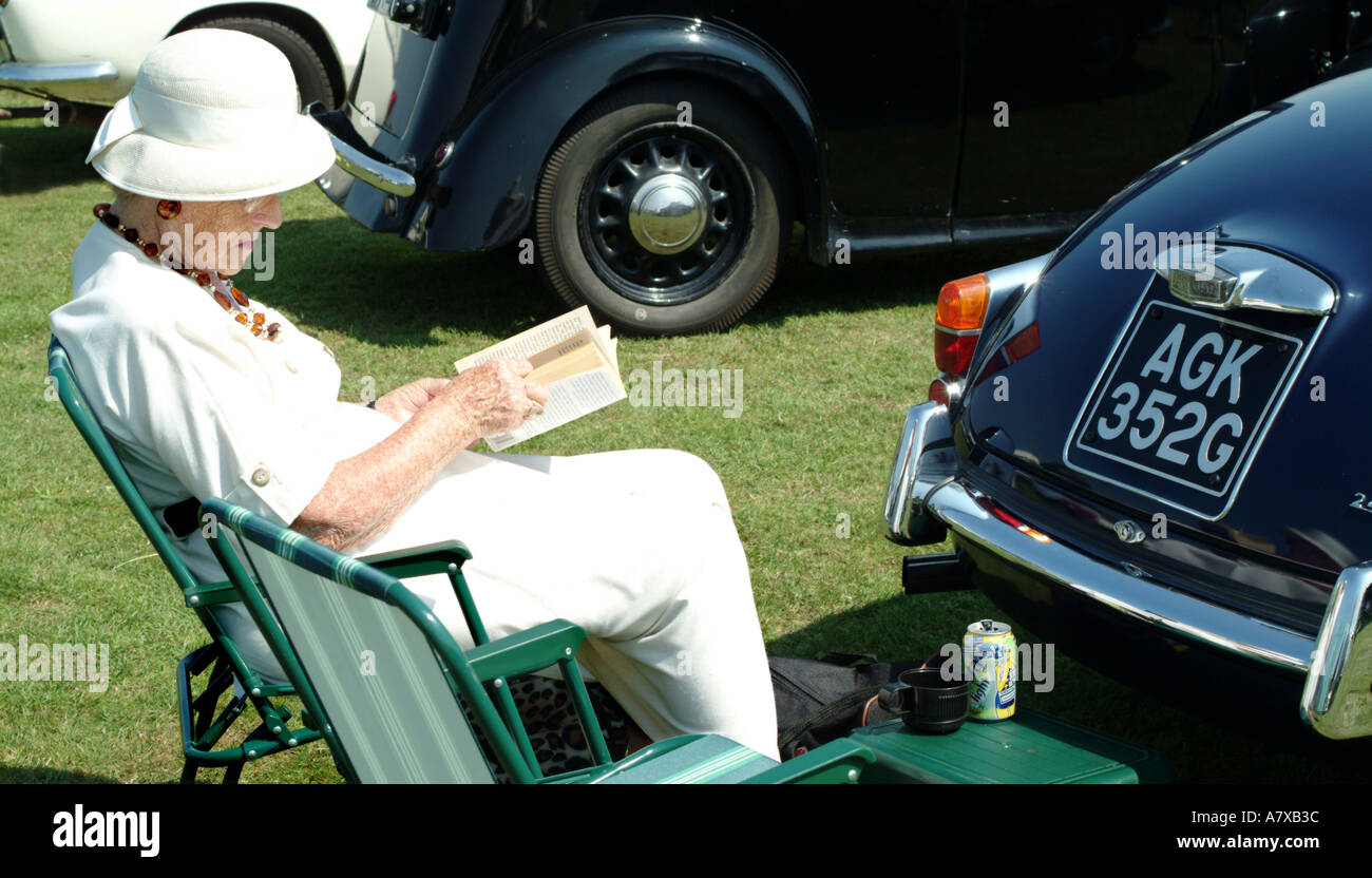 Vieille Femme montre son vieux classique voiture Daimler Banque D'Images
