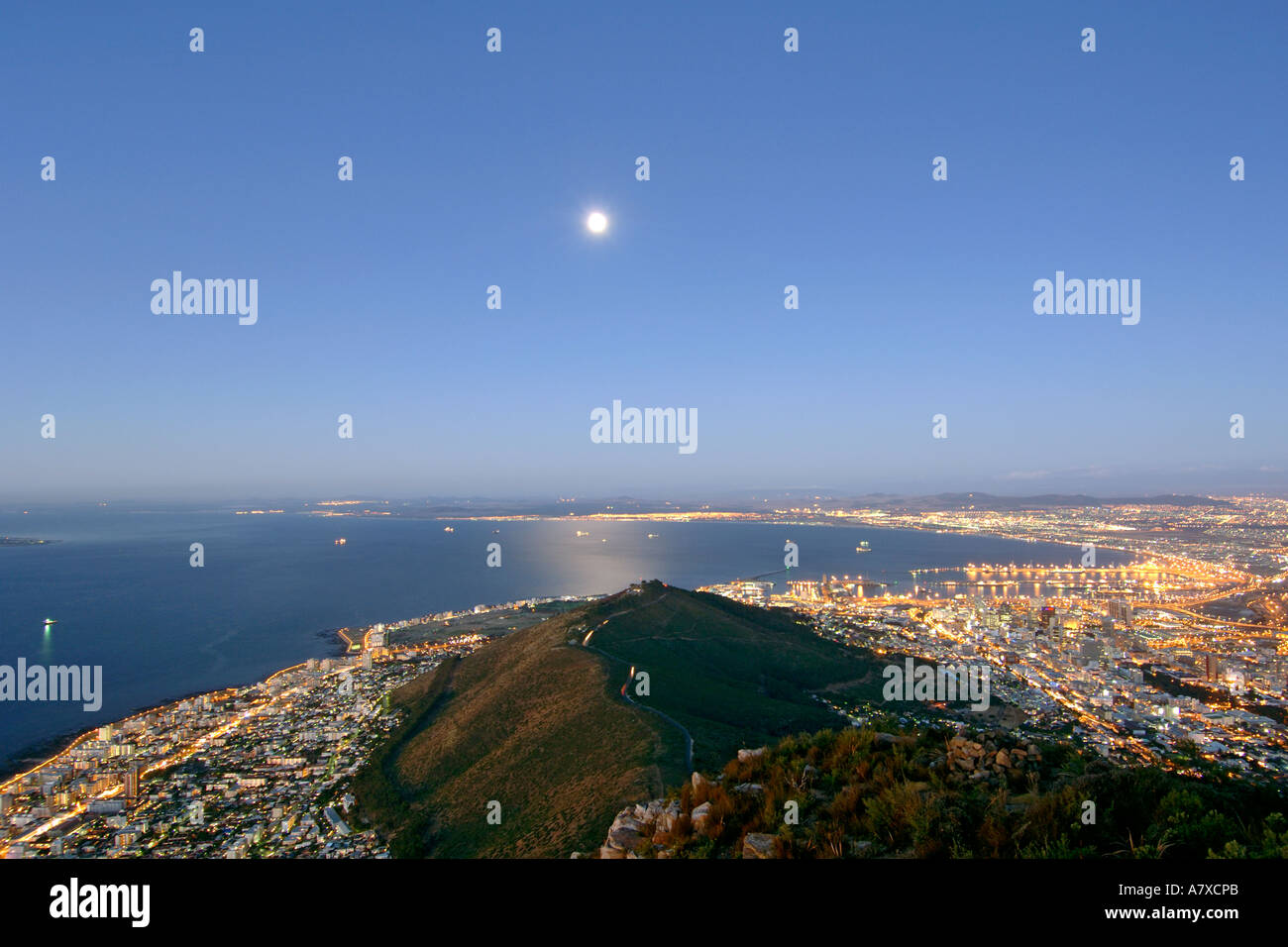 Vue de la ville du Cap, Signal Hill et la lune depuis le sommet de la tête de lion au crépuscule. La pleine lune est visible. Banque D'Images