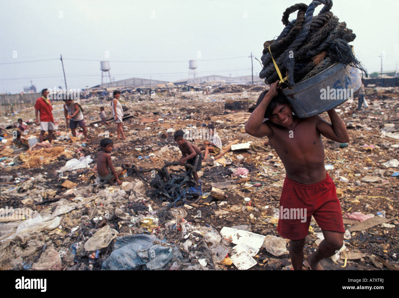 Aux Philippines, l'île de Luzon, les détritivores fouillent dans la poubelle du camp de squatters par port de pêche de Navotas à Manille Banque D'Images