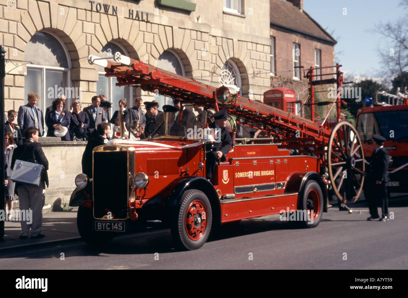 Les invités de mariage de Glastonbury sur et autour de la vieille machine à feu restaurée sur le point de s'éloigner de l'hôtel de ville Somerset Angleterre Royaume-Uni Banque D'Images