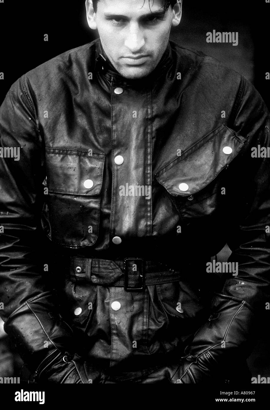 Portrait de jeune homme portant des vêtements moto par temps humide le noir et blanc Banque D'Images