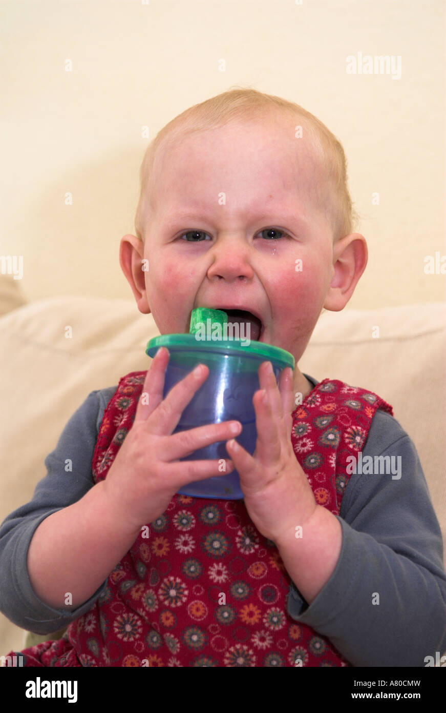 Little girl making faces de potable tasse anti-gouttes Banque D'Images