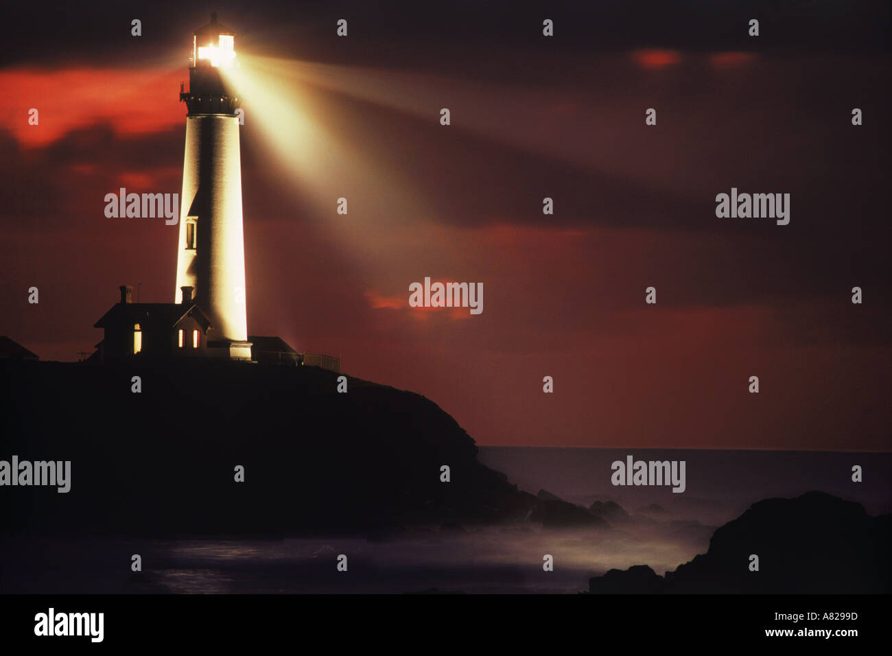 Pigeon Point Lighthouse dans l'ensemble de faisceau casting côte rocheuse et le coucher du soleil du ciel. L'image n'est pas modifié de façon numérique - Pas de photo shop. Du vrai ! Banque D'Images