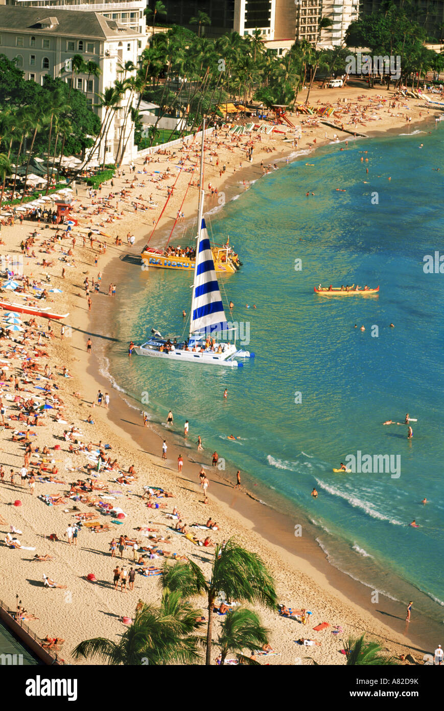 La plage de Waikiki à Honolulu avec catamarans, pirogue et baigneurs Banque D'Images