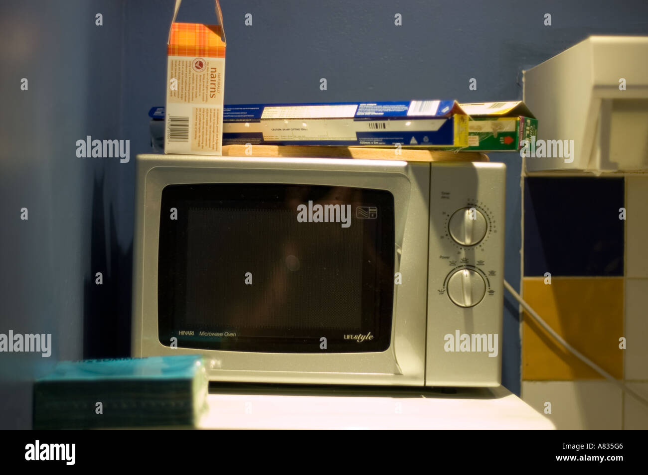 Un four micro-ondes dans un coin de murs bleus avec un couple de paquets de  pâtes placé sur elle Photo Stock - Alamy