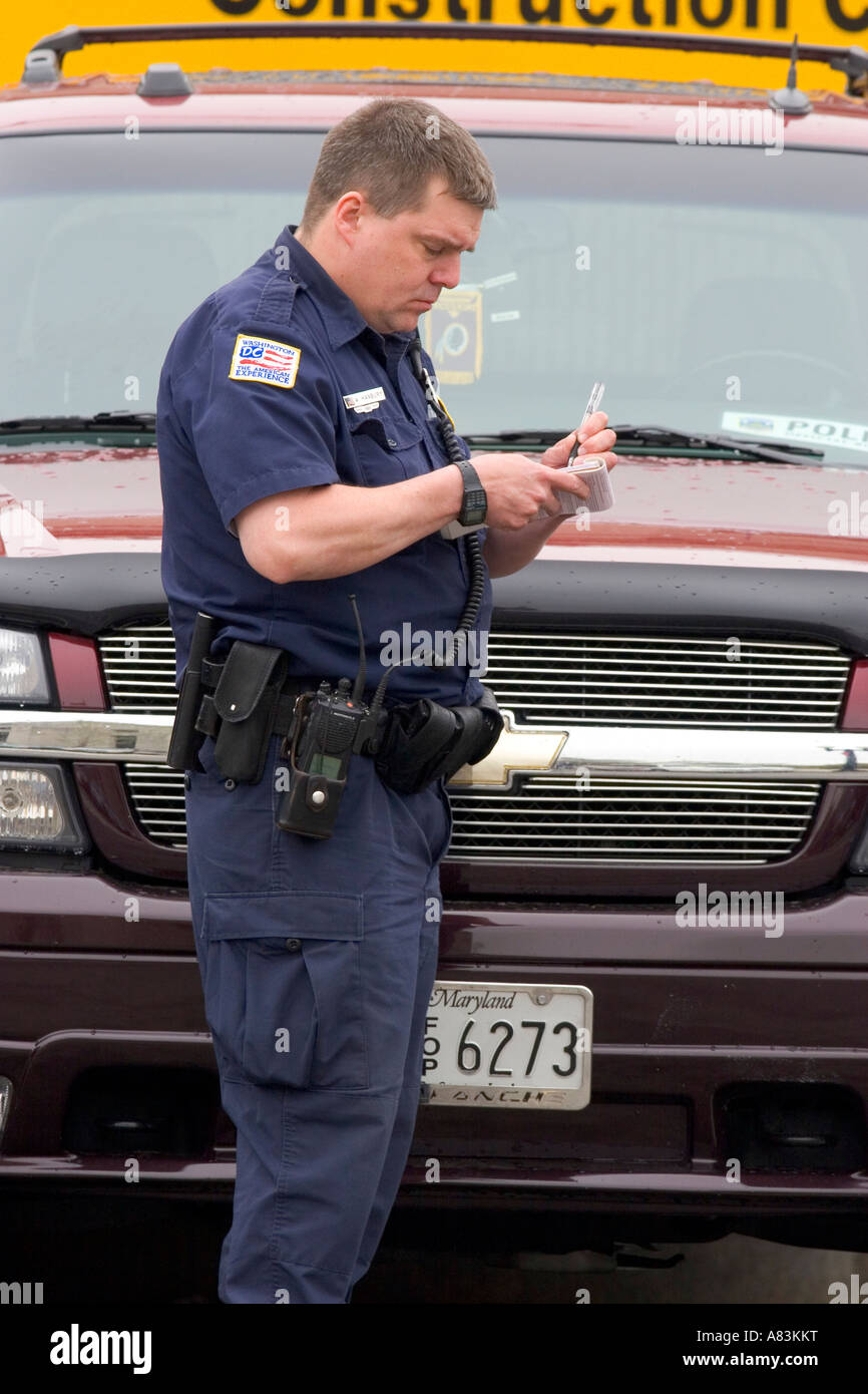 Agent de police écrit les billets de parking à Washington D C Banque D'Images