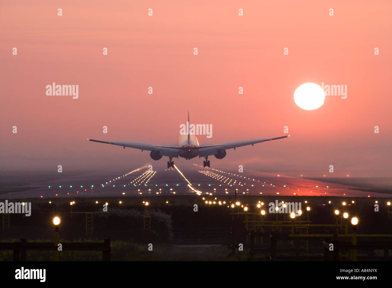 L'atterrissage de l'avion au lever du soleil. Banque D'Images