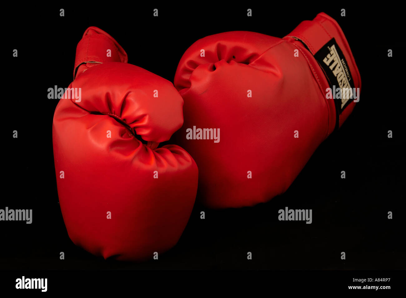 Gants de boxe, gants de boxe en cuir rouge sur fond noir. Banque D'Images