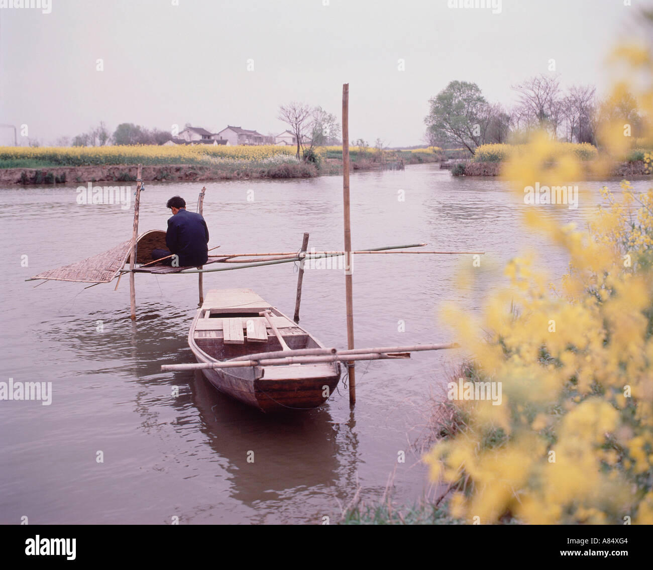 La Chine. La province de Jiangxi. La rivière Gan. Le pêcheur local décisions canopy pour son bateau à rames. Banque D'Images