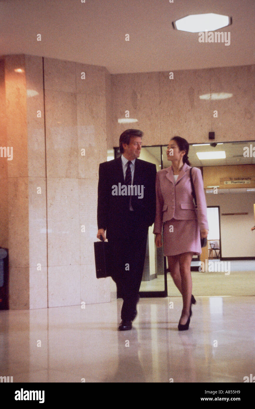 Deux collègues de marcher dans le couloir du bâtiment moderne. Banque D'Images