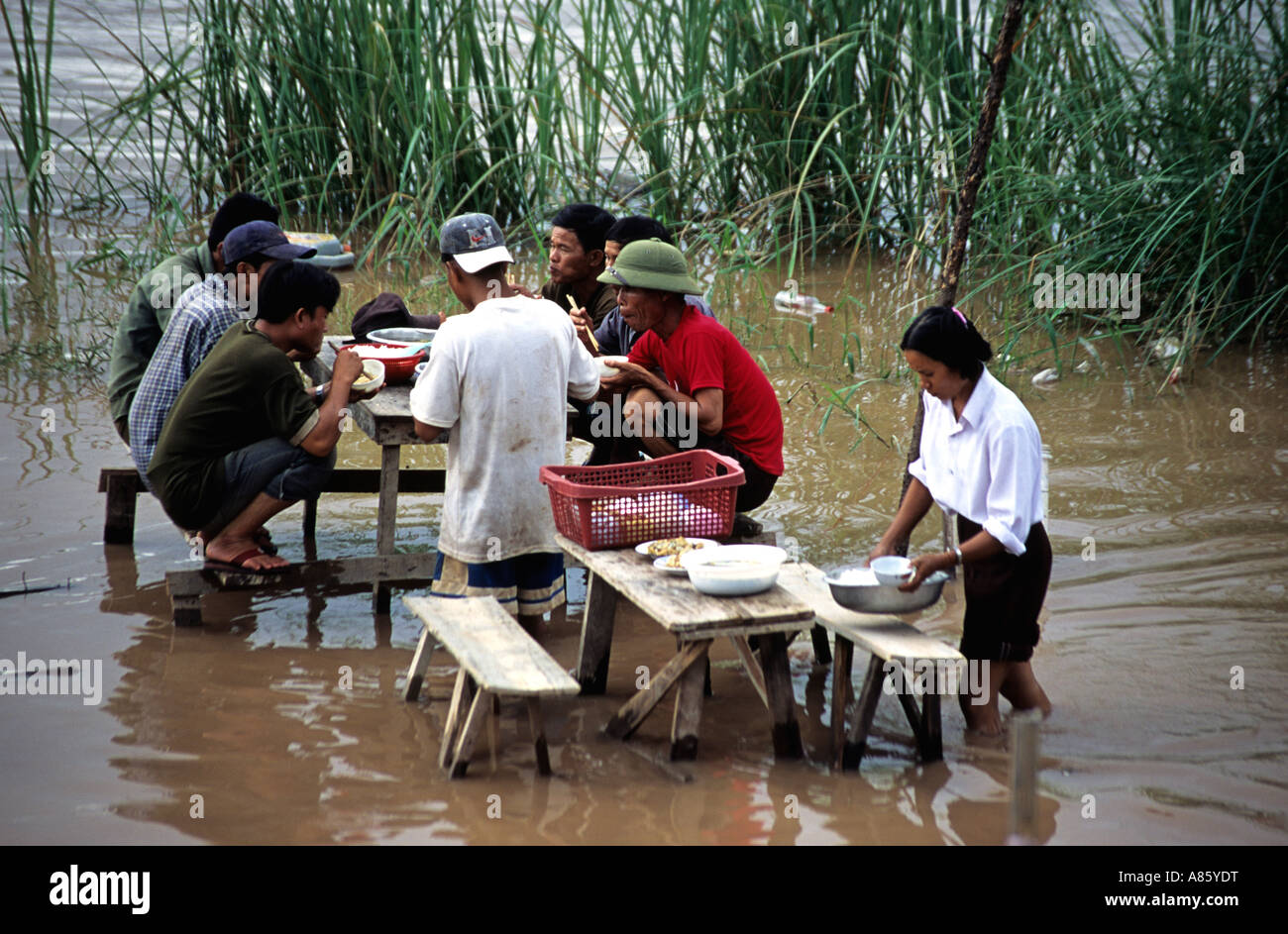Serveuse servant le déjeuner à un restaurant inondé à Vientiane Laos,. Le fleuve du Mékong. Banque D'Images