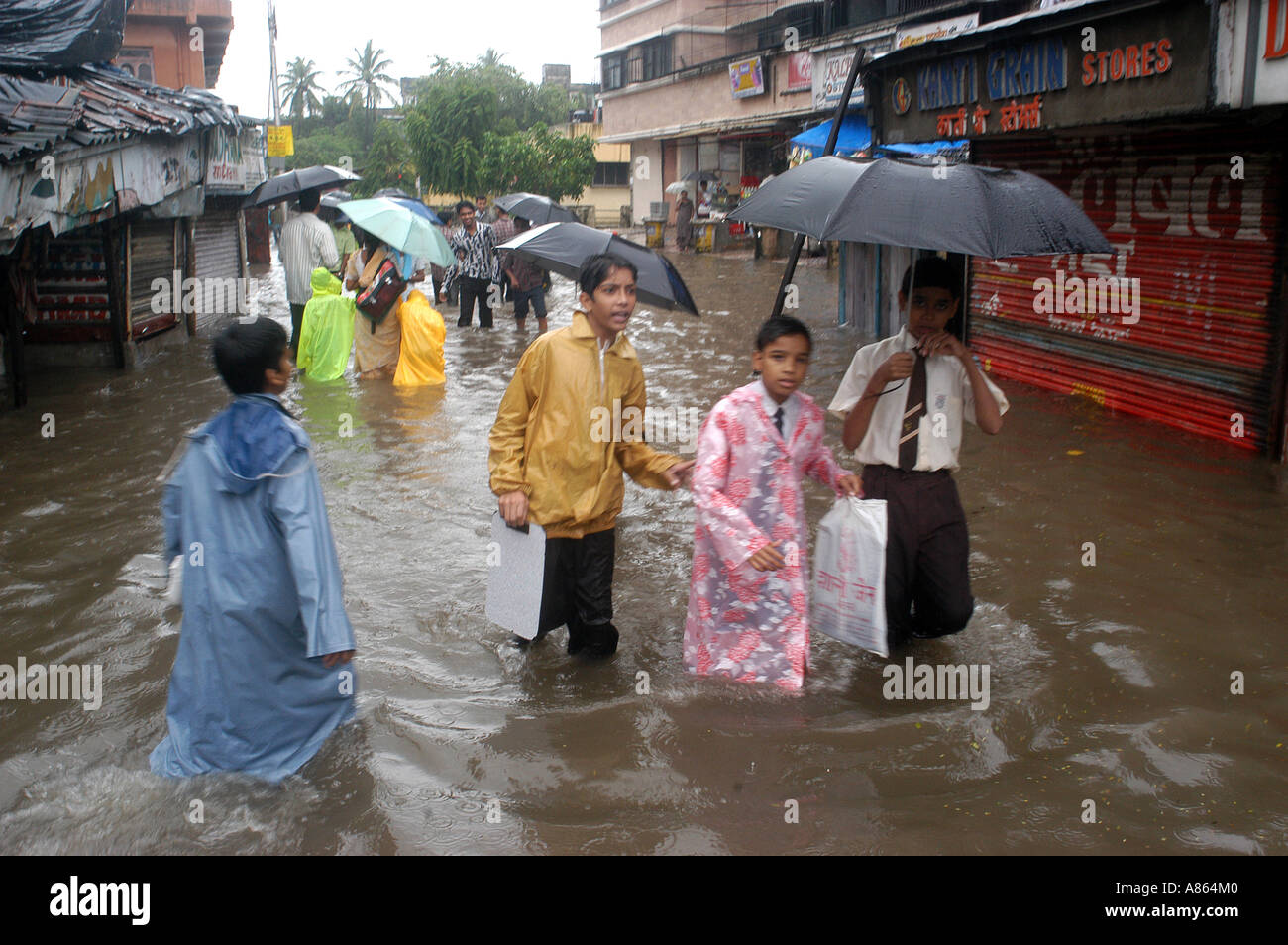 Les enfants de l'école indienne sur la rue inondée de fortes pluies de mousson en journée dans la ville de Mumbai Bombay Inde Banque D'Images