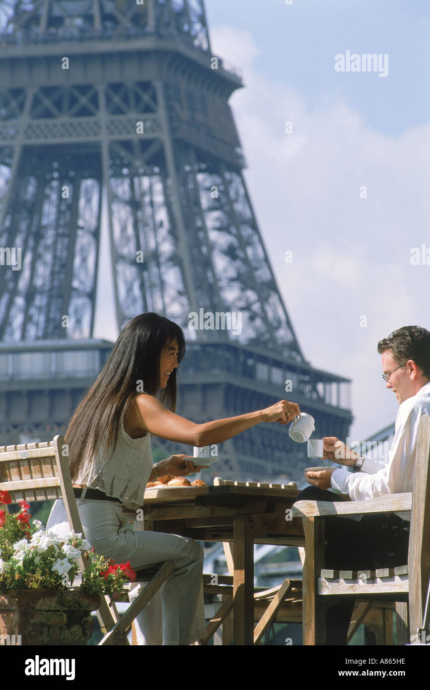 Couple having breakfast sur Seine péniche à Paris avec la Tour Eiffel au-delà Banque D'Images