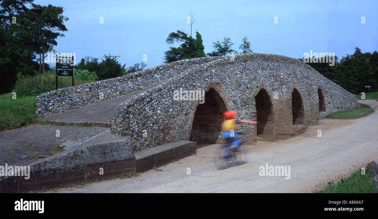 Pack Horse Bridge à Moulton Suffolk UK boy riding passé sur le vélo Banque D'Images