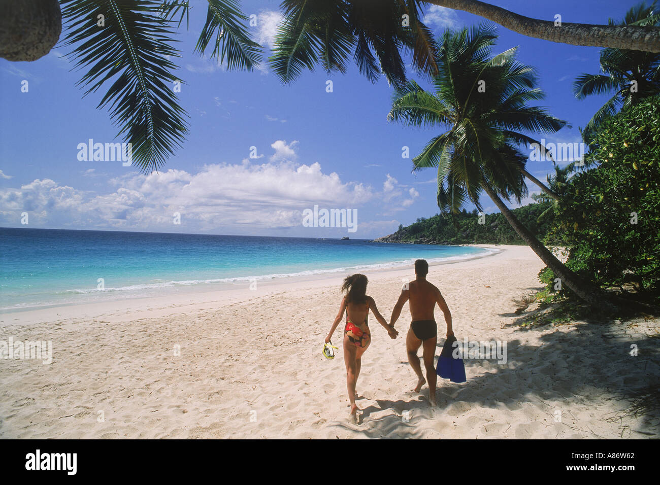 Couple sur le sable blanc d'Anse Intendance sur l'île de Mahé aux Seychelles Banque D'Images