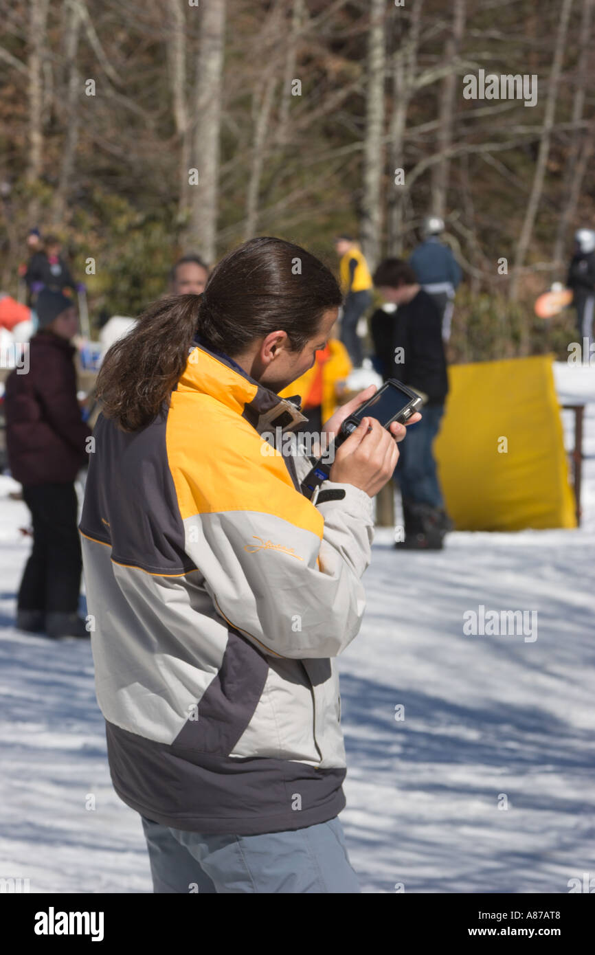 L'homme utilise PDA tandis que sur pistes de ski des Sugar Mountain Resort dans la région de Banner Elk, North Carolina, USA Banque D'Images