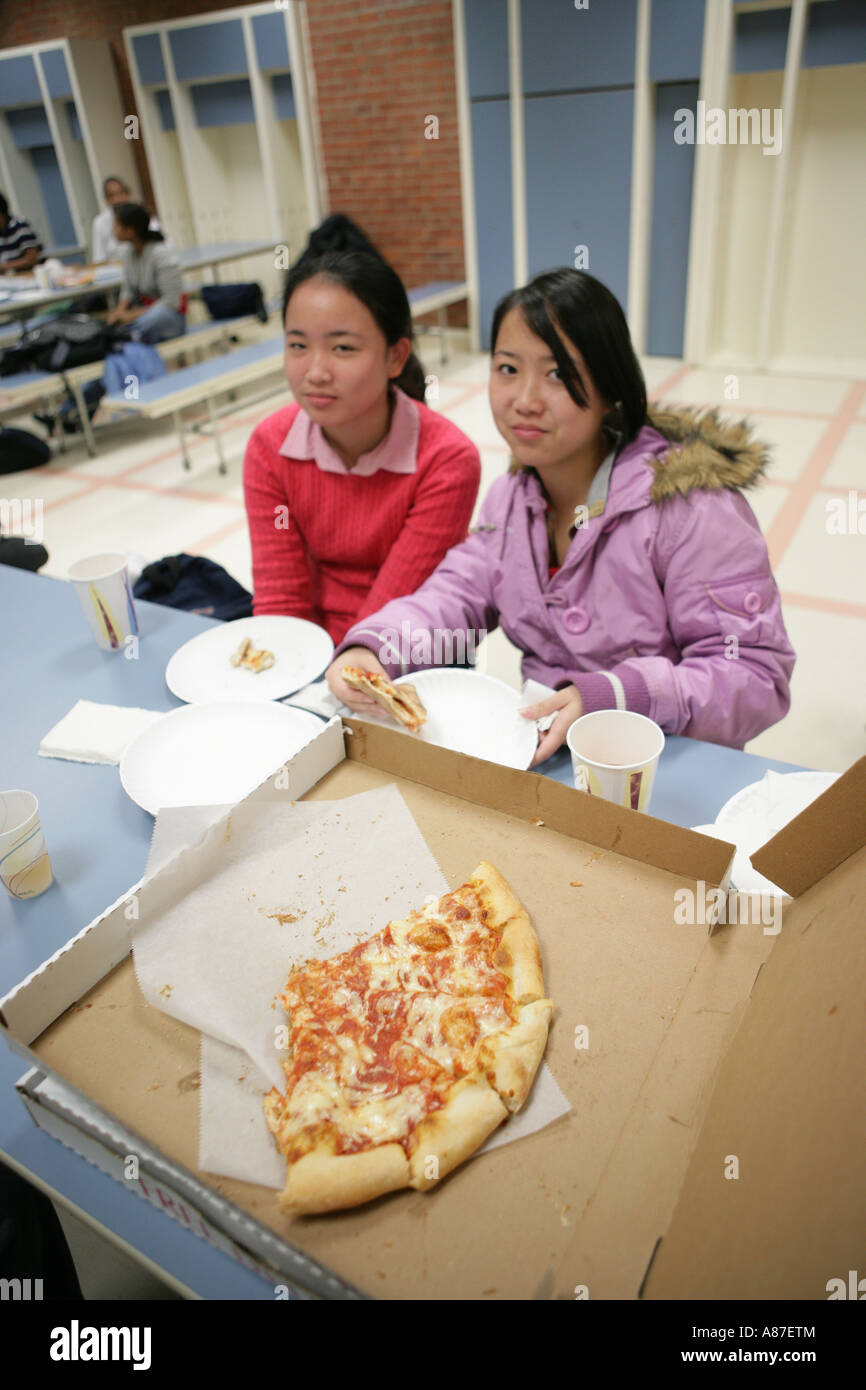 Les filles (16-17) eating pizza in canteen, portrait Banque D'Images