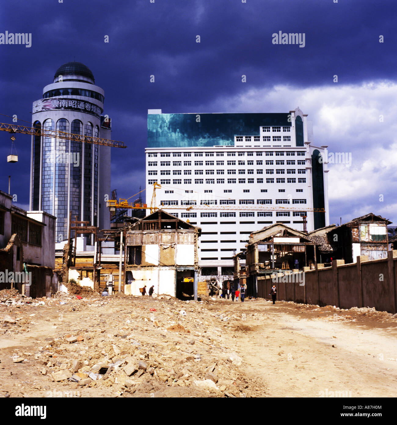De nouveaux bâtiments d'affaires moderne,se lever sur les ruines de démoli des maisons traditionnelles sous un ciel d'orage,Kunming, Chine Banque D'Images