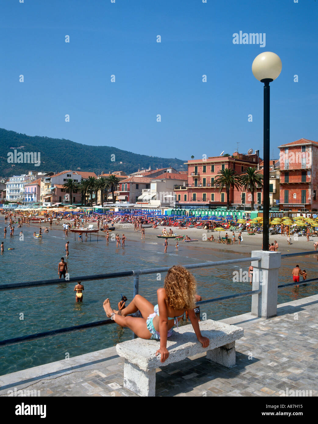 Fille assise sur le bord de mer à Alassio, Savone, Ligurie province,  Riviera Italienne, Italie Photo Stock - Alamy