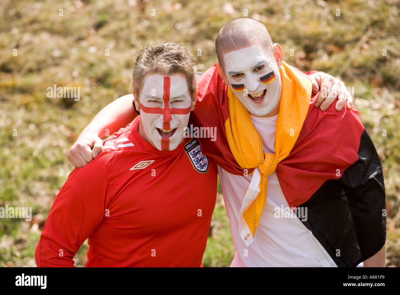 L'Angleterre et l'Allemagne de football fans enlacés dans un bon esprit, happy smiling faces peintes avec des couleurs nationales. Banque D'Images