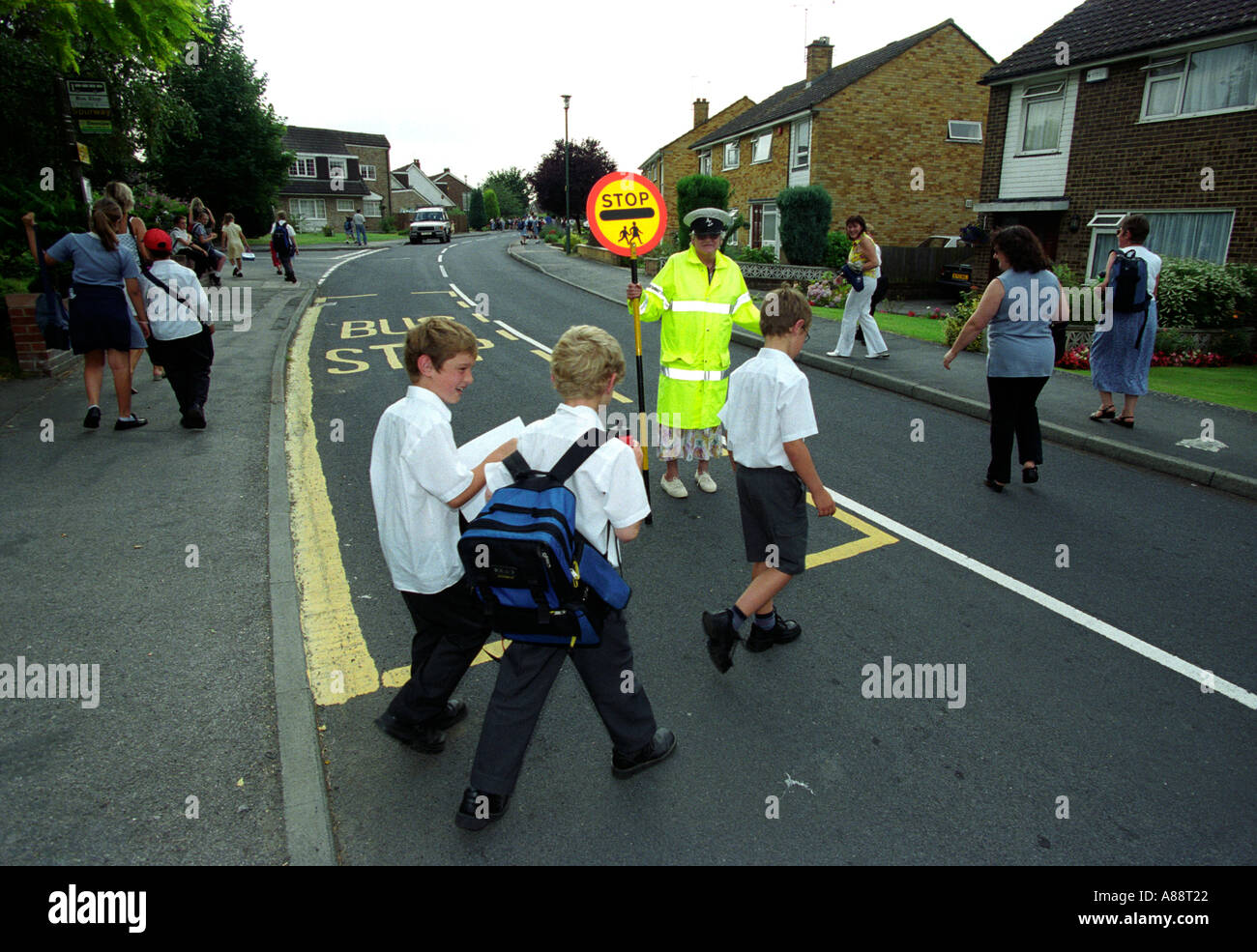 Les enfants traversent la route avec l'aide de Touch of Pink Lady après l'école la journée, Maidstone, Kent, UK. Banque D'Images