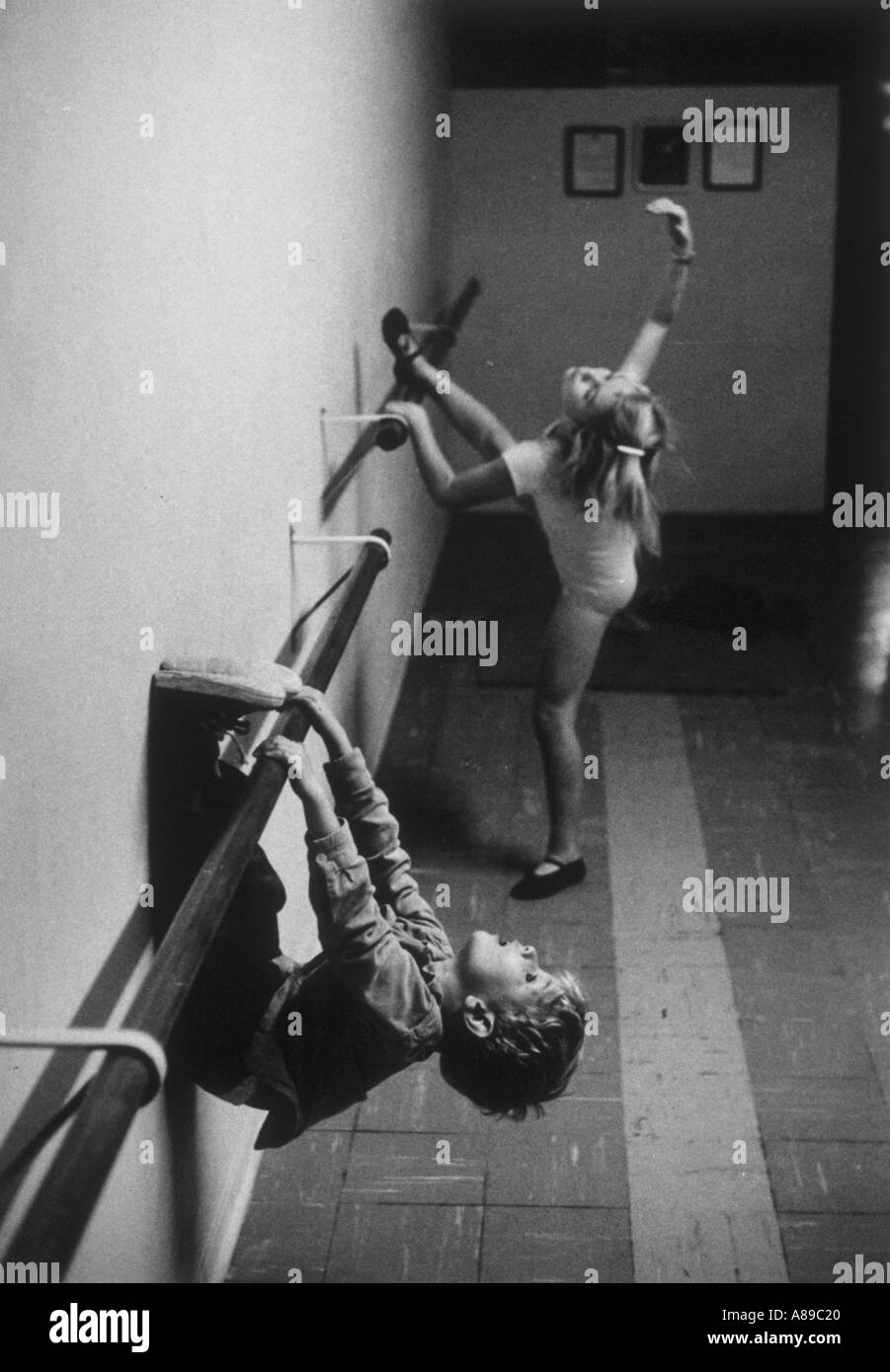 Petit garçon joue sur la balustrade de danse Danse à sa sœur pendant qu'elle classe dans les pratiques de l'arrière-plan Banque D'Images