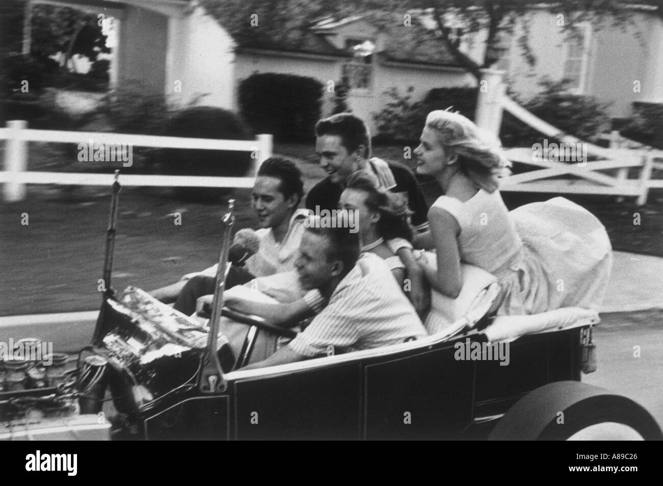 Groupe de jeunes garçons et filles prennent une virée dans un millésime 1950 Droit convertible a été prise dans les années 1950 Banque D'Images