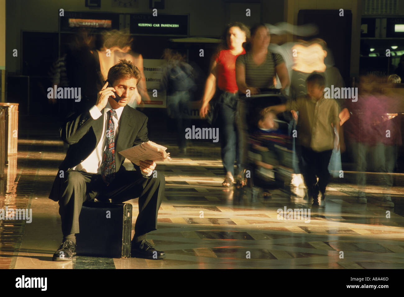 Woman talking on cellphone porte-documents et la lecture du papier dans la gare de Los Angeles Banque D'Images