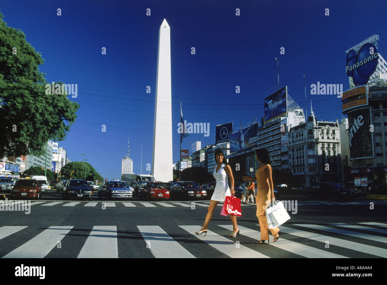Deux femmes avec des sacs à traverser l'avenue 9 de Julio, près de Obelisko à Buenos Aires Banque D'Images
