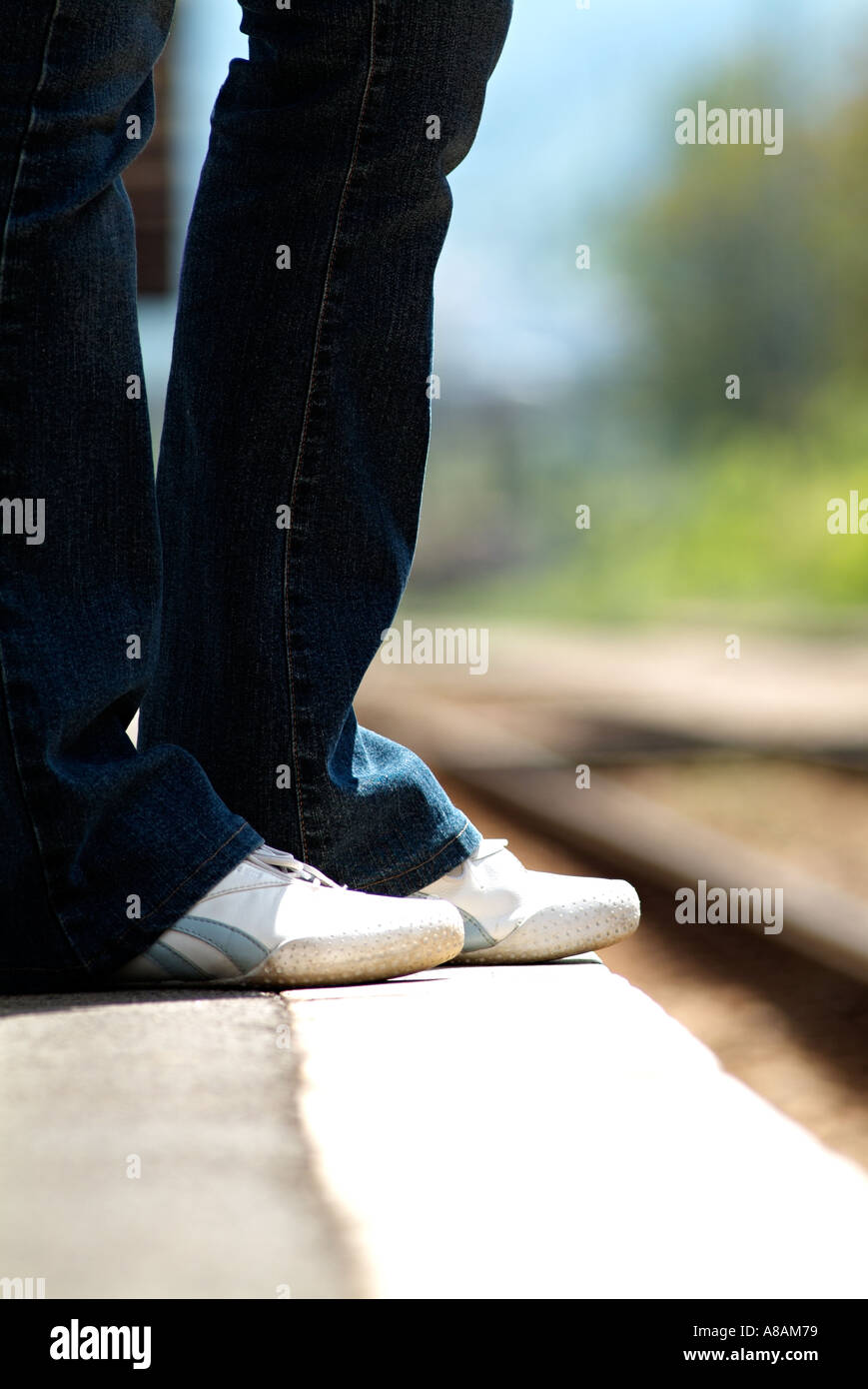 Femme Debout sur le bord d'une plate-forme du train en gare en attente d'un train, Close Up. Banque D'Images