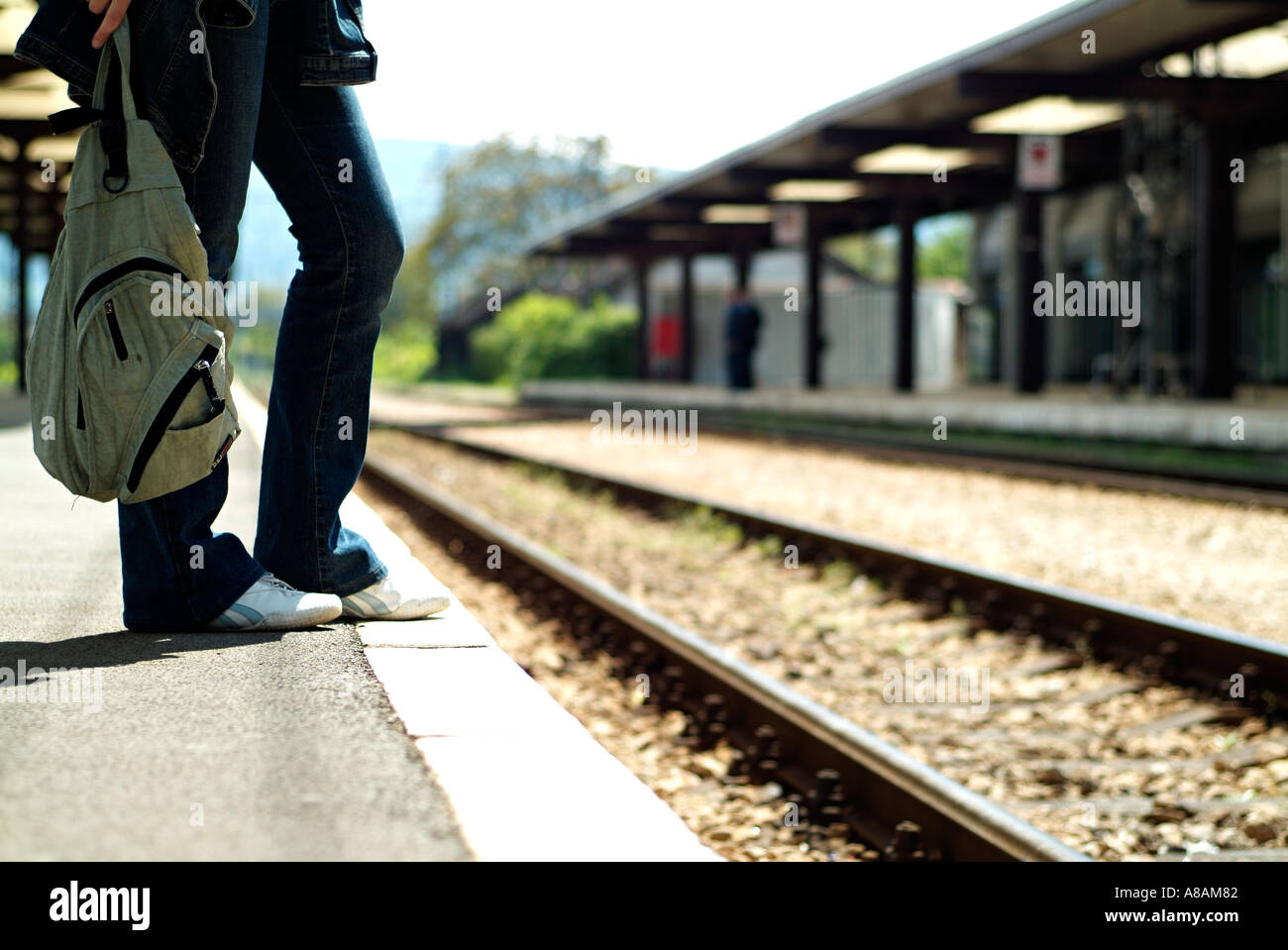 Femme Debout sur le bord d'une plate-forme du train en gare en attente d'un train Banque D'Images