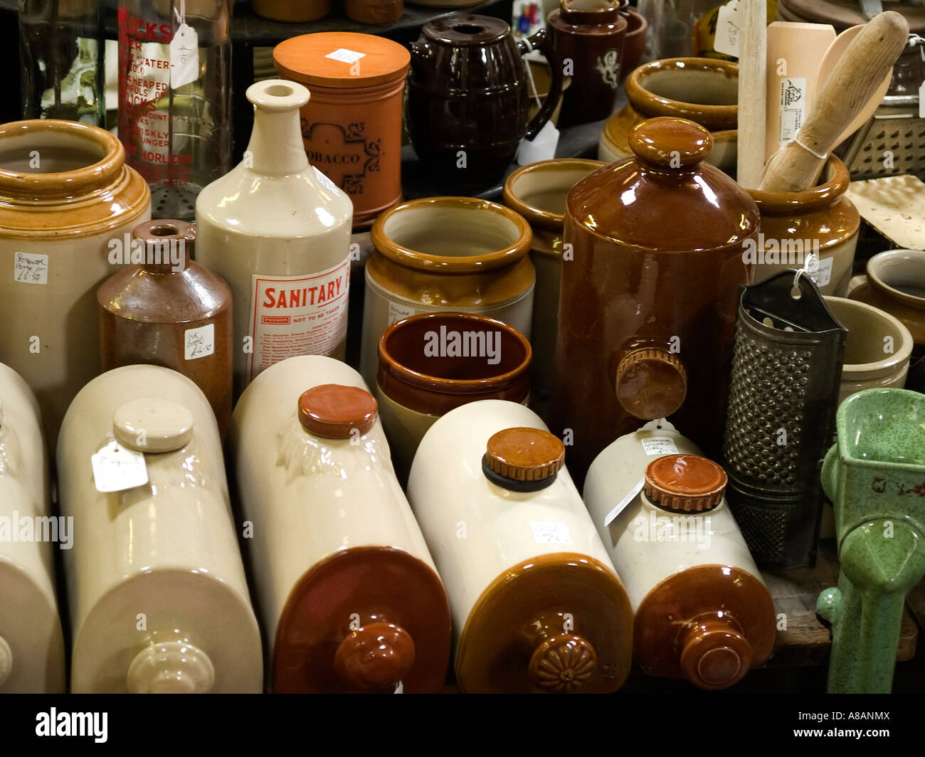 Des bouteilles d'eau chaude de la pierre et des bocaux en vente sur une brocante à Whitby Banque D'Images