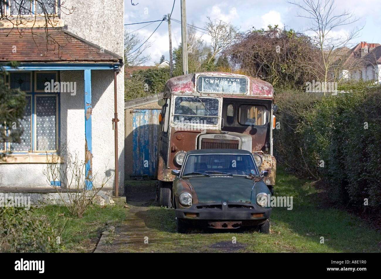 Vieille voiture de sport et de bus d'époque à l'extérieur de la maison délabrée à Chepstow Banque D'Images