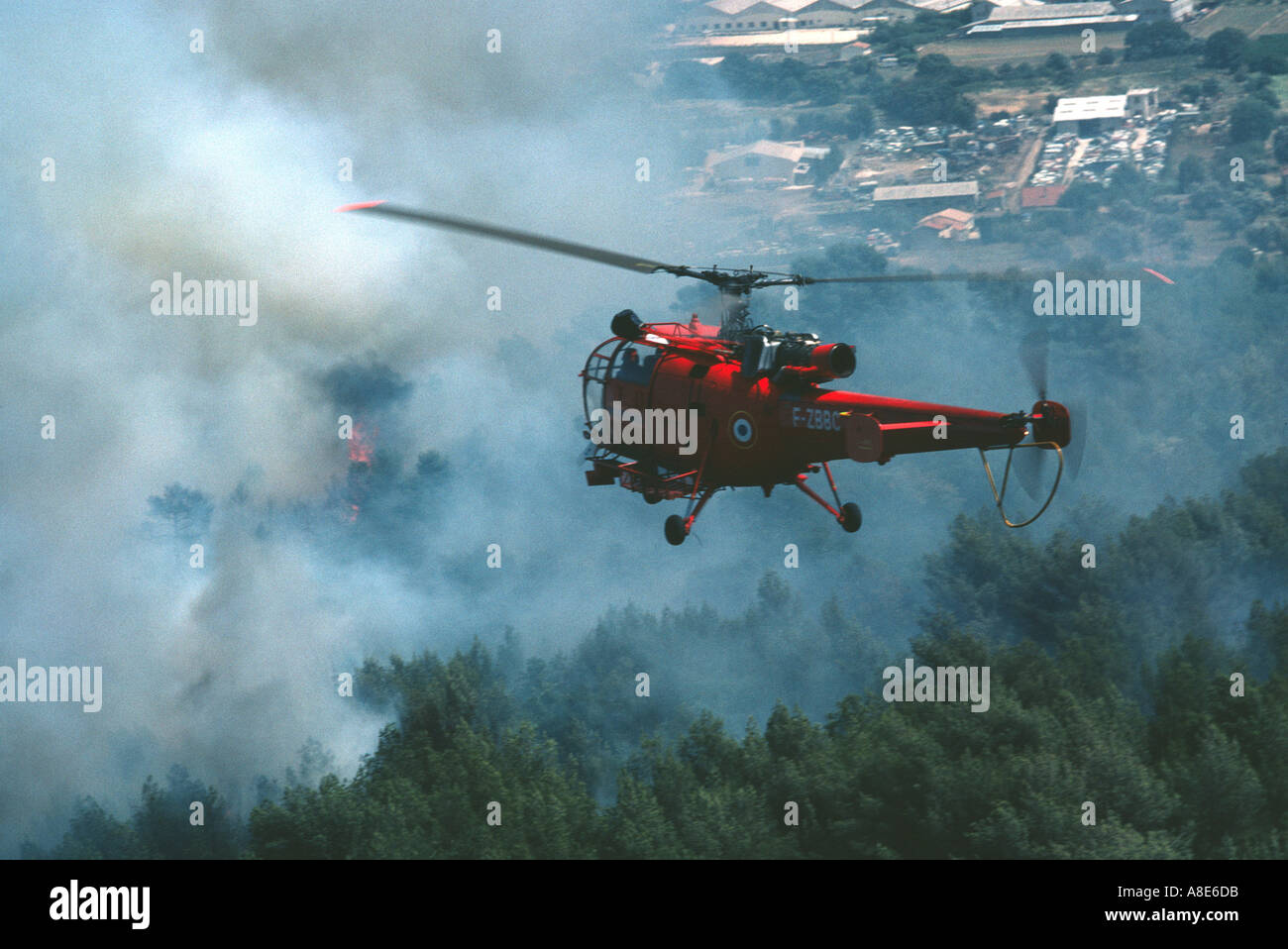 La commande de vol de l'hélicoptère Alouette III pompiers planant en face d'un nuage de fumée du feu, Provence, France, Europe, Banque D'Images
