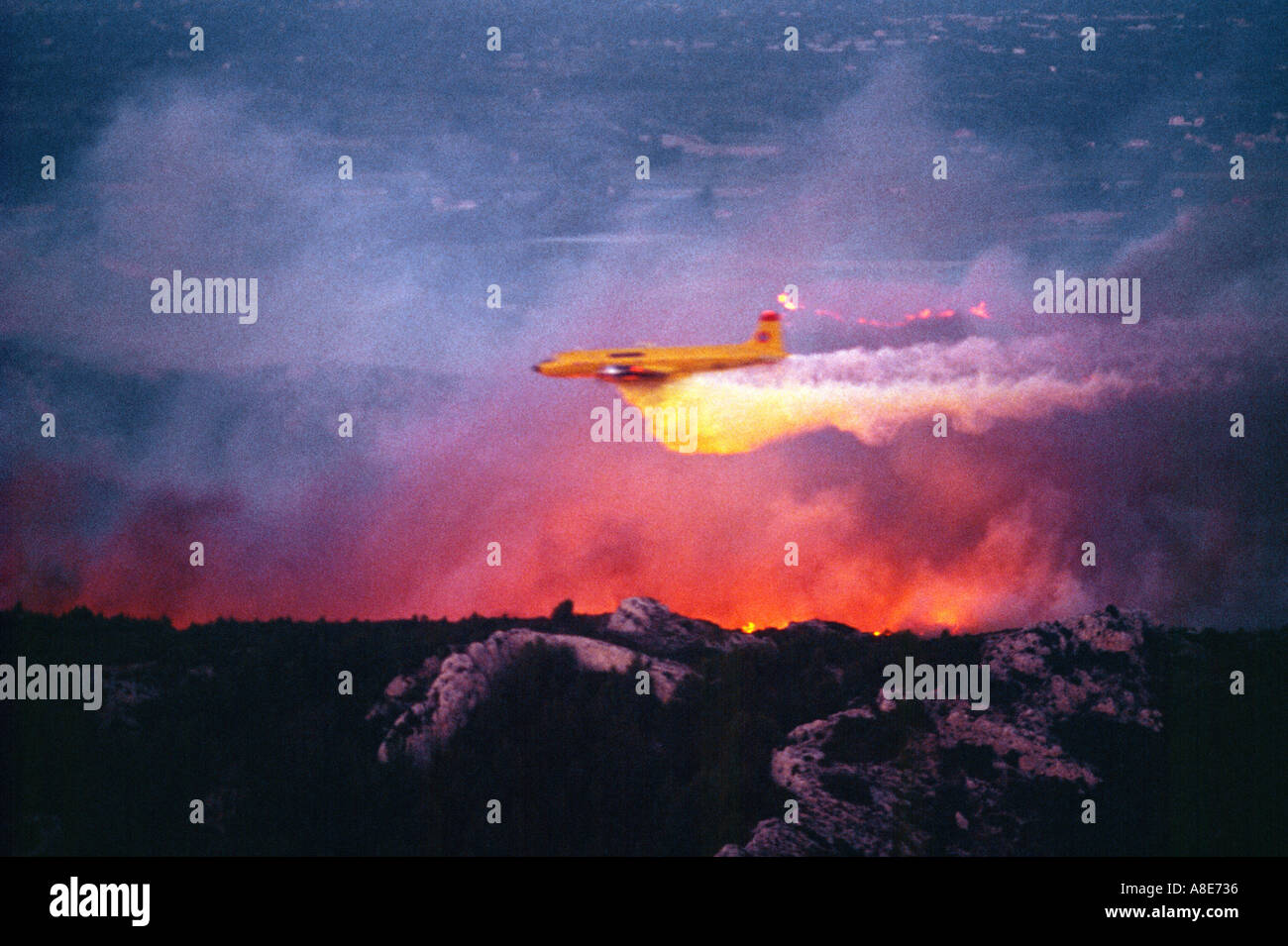 Vue aérienne d'un Douglas DC-6B avion bombardier d'eau de lutte contre l'abandon au feu sur une forêt au crépuscule, flammes, Provence, France, Europe, Banque D'Images